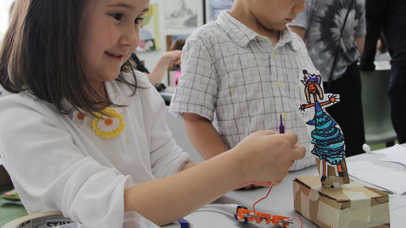 A student demonstrates her Dancing Doll kinetic sculpture.