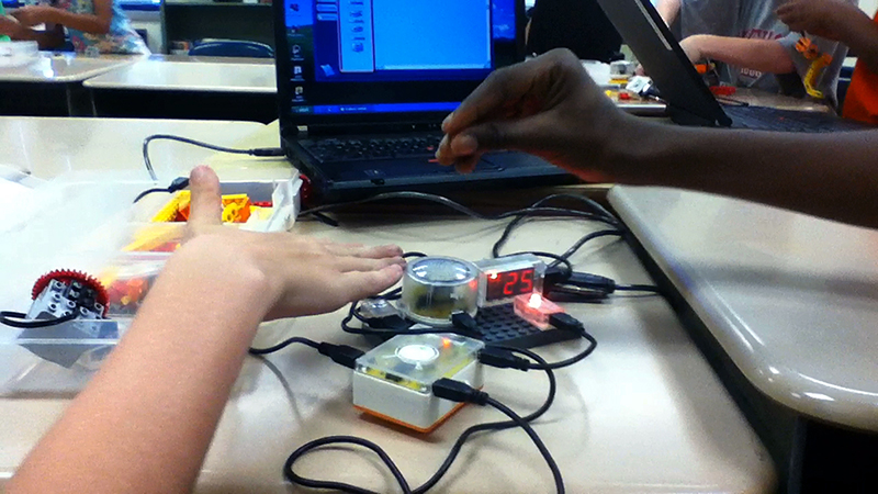 Two students demonstrate their interactive sound sculpture.